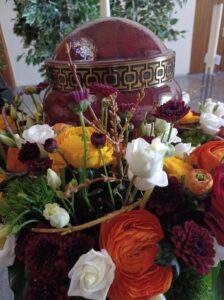 Urne mit Blumenkranz